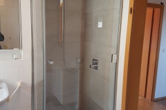 Eckige Ganzglasdusche mit Metallbeschlägen